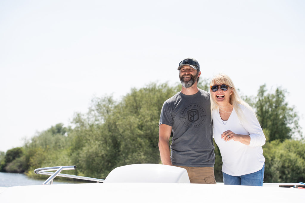 Man and a woman on a Norfolk Broads hire boat